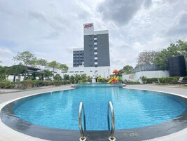 Una piscina al aire libre, sillones reclinables de piscina