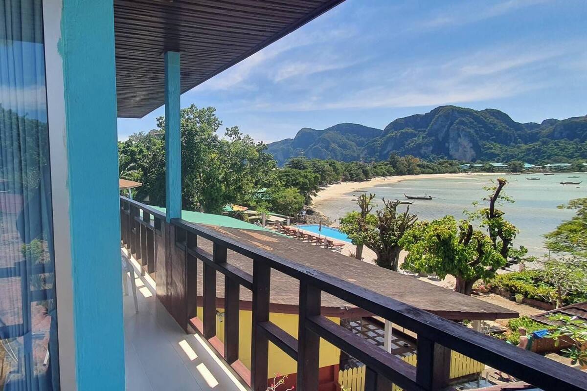 A balcony with a view of a beach and mountains.