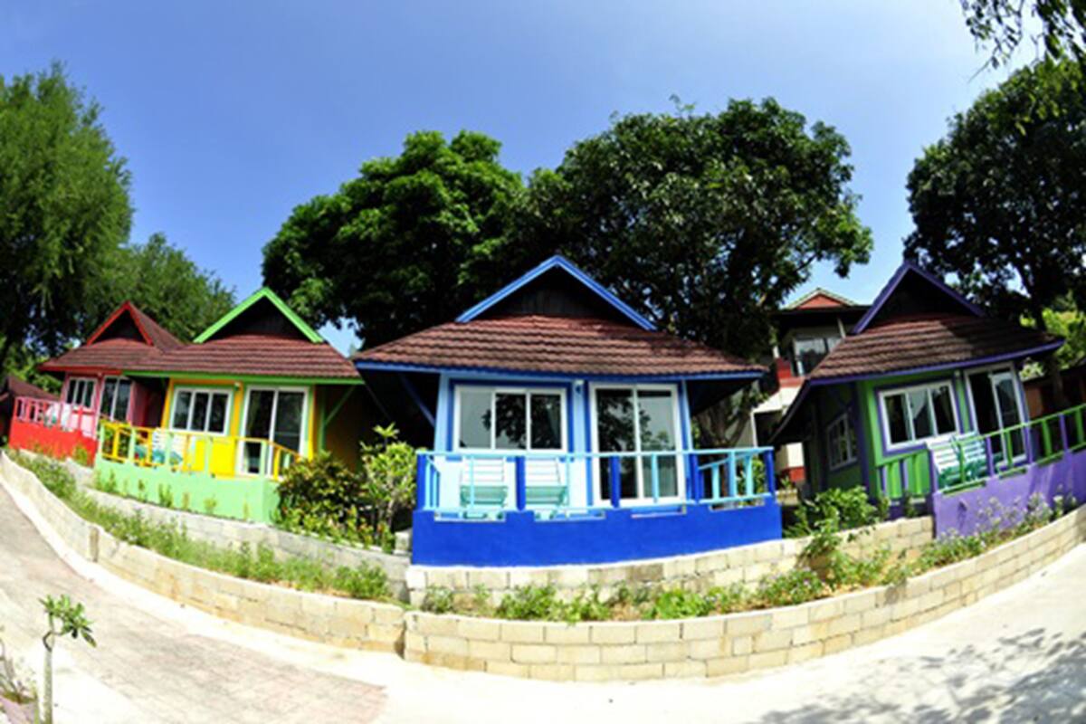 A row of colorful houses with distinct roofs and a clear sky.
