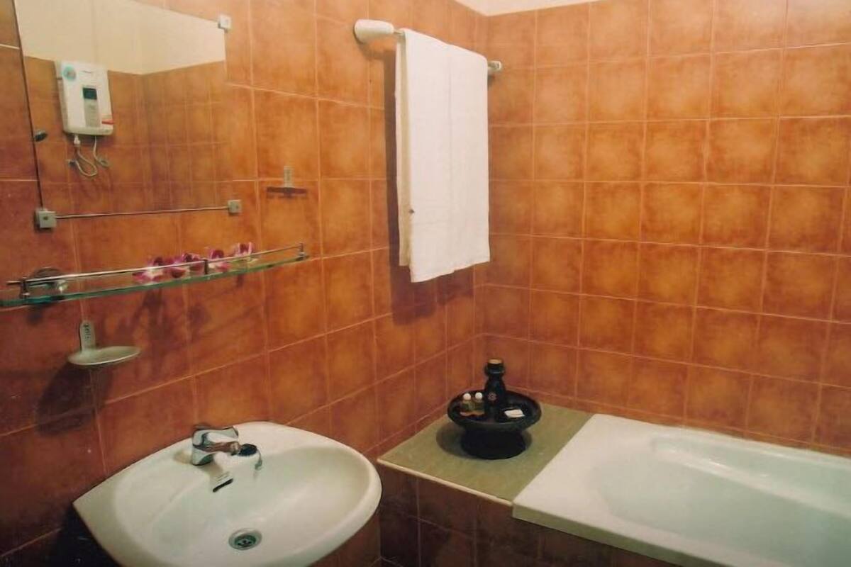 Ein Badezimmer mit Waschbecken, Badewanne und einem Handtuch an der Wand.