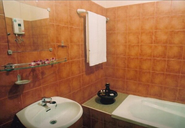 Une salle de bain avec un lavabo, une baignoire et une serviette accrochée au mur.