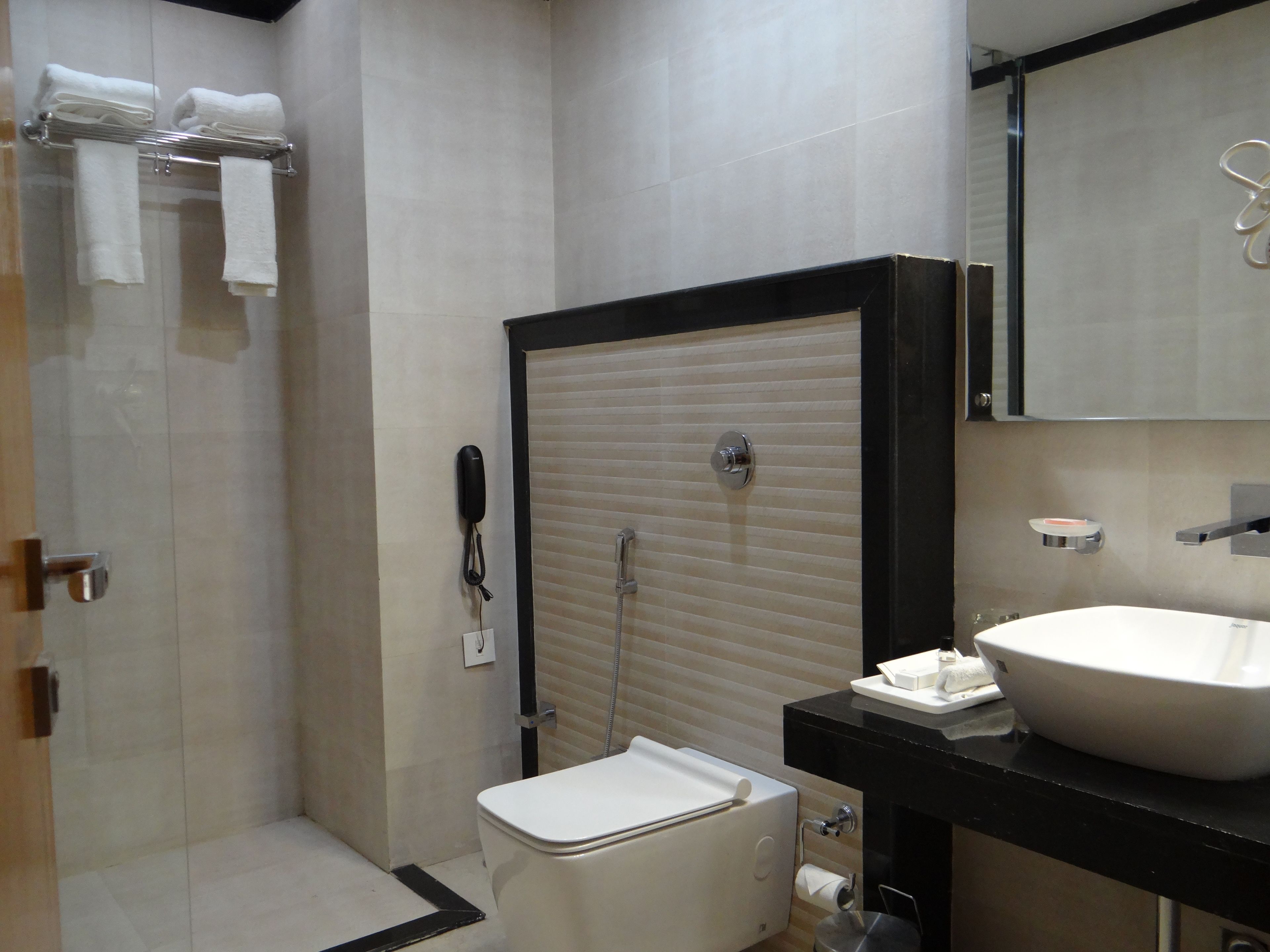 A modern bathroom with a toilet, sink, and shower.