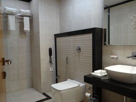 A modern bathroom with a toilet, sink, and shower.
