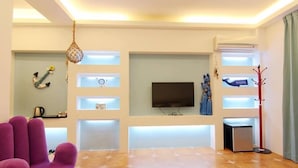 A modern living room with a flat-screen TV, a coffee machine, and a red coat rack. - Zi Jing Fang lnn (Hengchun)