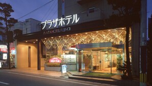 Un hotel con fachada moderna, entrada visible y señalización que indica servicios como café y almuerzo.
