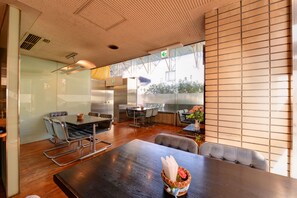 Una zona de menjador moderna amb una taula de fusta gran i seients còmodes.