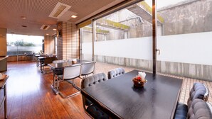 Un salón de conferencias con una mesa grande, sillas y un sofá.
