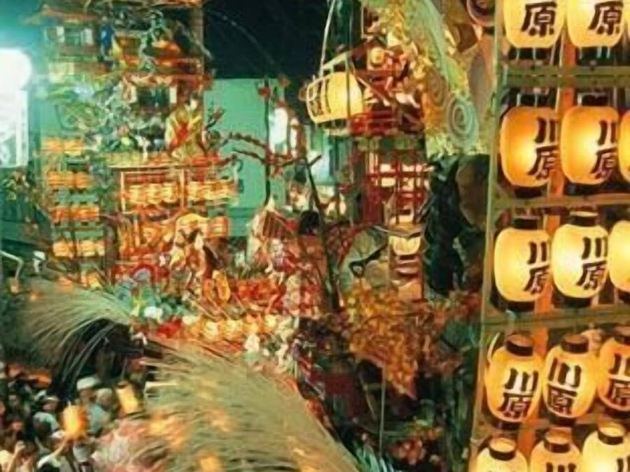 A crowded indoor market with various stalls and hanging lanterns.