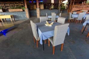 Ein Restaurant mit Außenbereich, Tische mit blauen Tischdecken und Holzstühle.