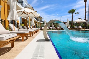Una piscina al aire libre de temporada, sombrillas