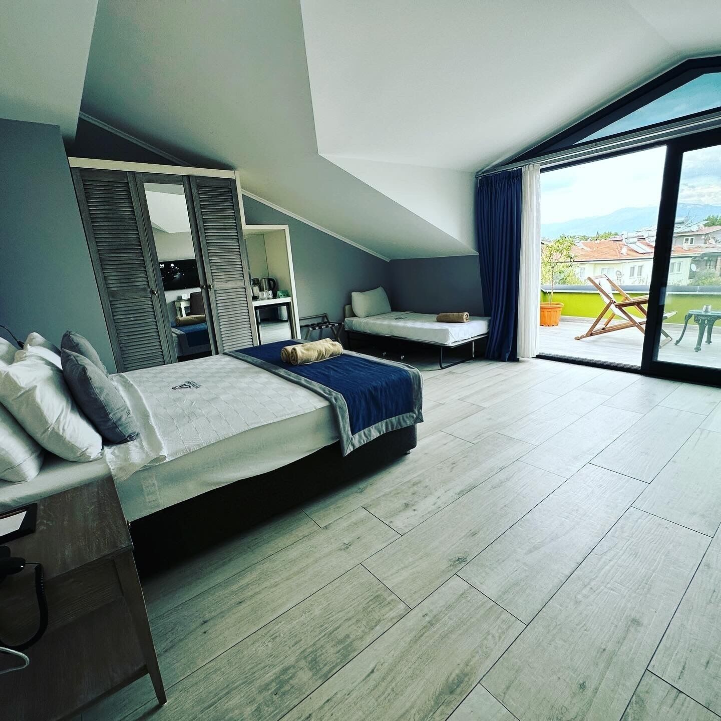 Une chambre d’hôtel moderne avec un grand lit, un bureau et un balcon offrant une vue agréable.