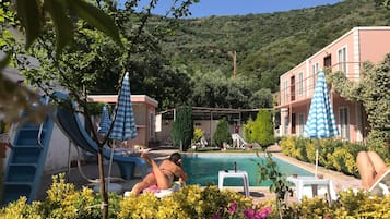 Piscine extérieure, parasols de plage, chaises longues