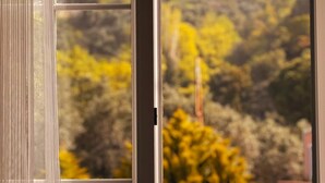 A window with a view of trees and a building in the background. - Ali Baba Butik Otel (Marmara)