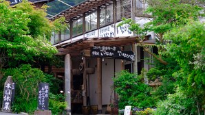 Un edificio japonés tradicional con estructura de madera y un corredor cubierto.