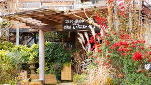 Un jardín con diversas plantas y una pérgola de madera.