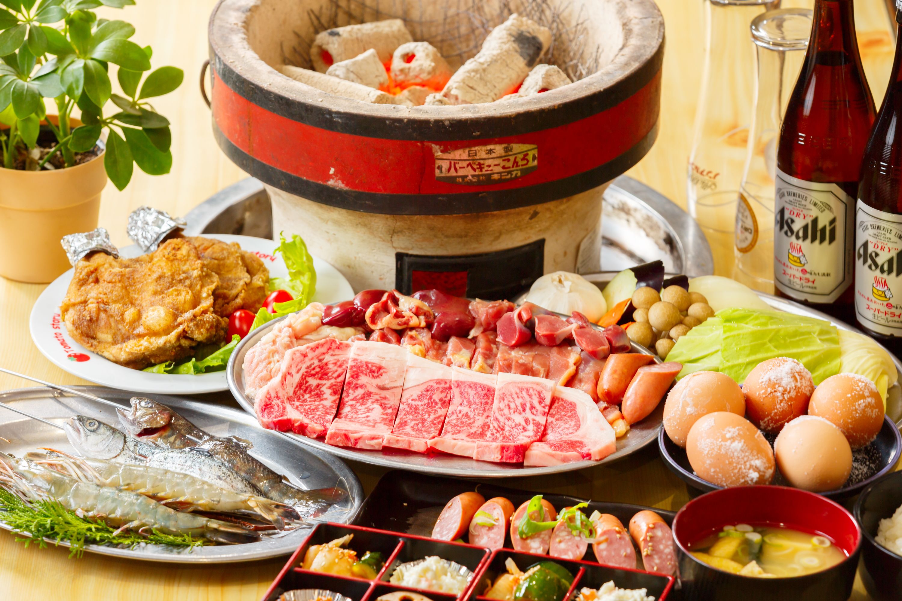 Un assortiment de plats comprenant du poisson, de la viande et des légumes, avec un plat japonais traditionnel à base de bouillon au centre de la table.