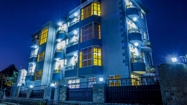 A multi-story hotel with balconies and illuminated windows. - Guzara Hotel Addis (Addis Ababa)