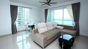 A modern living room with a sofa, a coffee table, and a ceiling fan. - StayNest Suites at Gurney Drive (George Town)