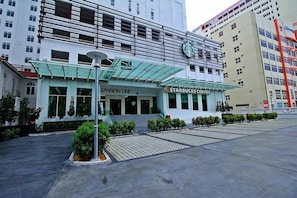 A modern building with a Starbucks Coffee and a sign for 'Mansion One'. - StayNest Suites at Gurney Drive (George Town)