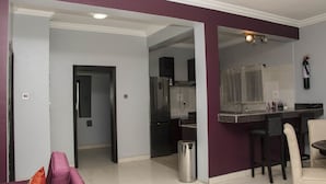 Een moderne keuken met een koelkast van roestvrij staal, een spoelbak en een bar met krukken.