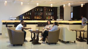 A lobby area with seating arrangements, a bar with a variety of liquor bottles, and a cashier counter. - Berlottue Hotel (Addis Ababa)