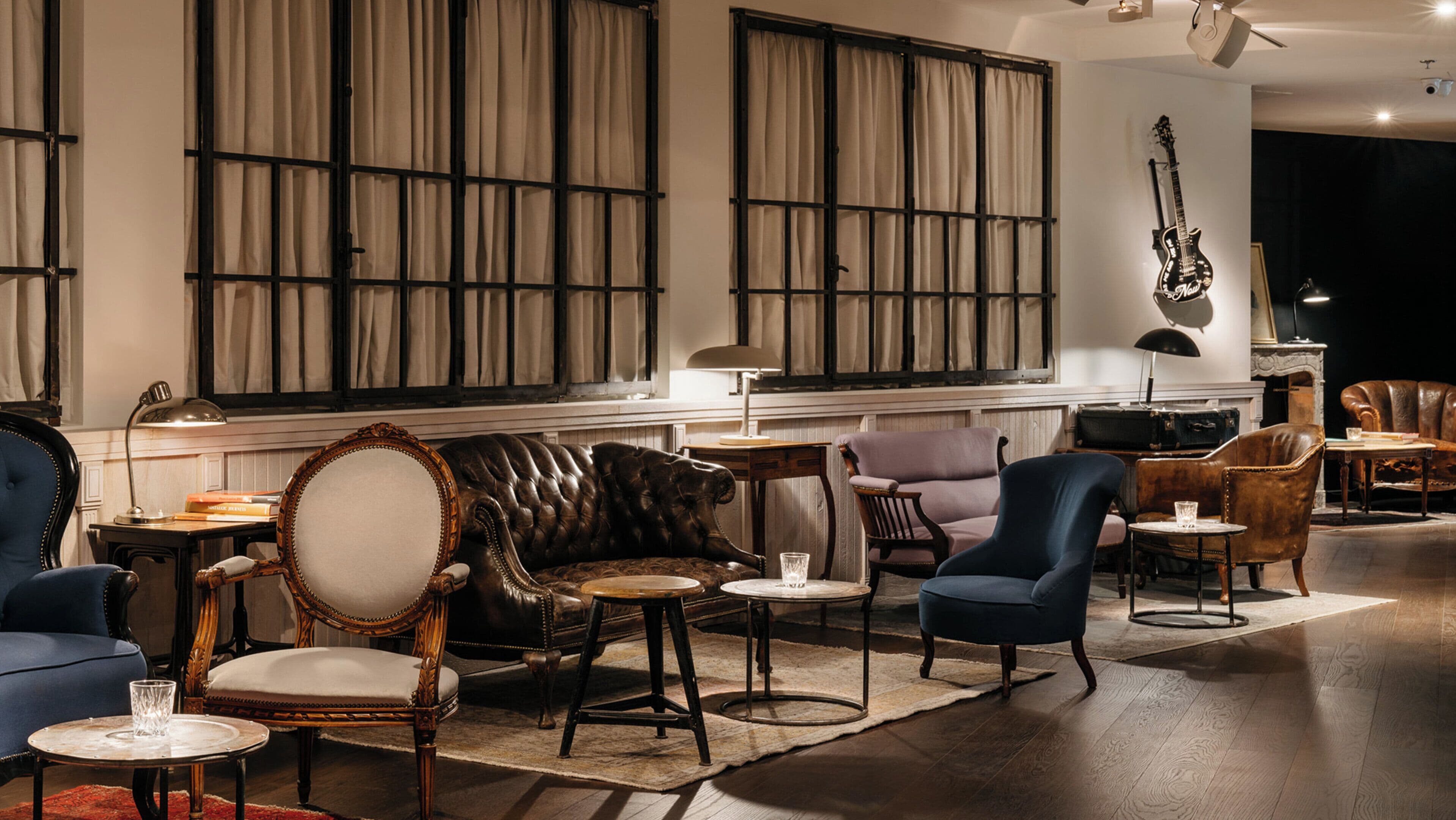 Un vaste espace de détente avec des canapés et des fauteuils en cuir, ainsi qu’un piano.