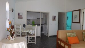 A compact living space with a dining area, kitchenette, and a sofa. - Apartamentos Quinta Girassol (Loulé)