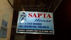 A sign for SANTA House offering hot & cold showers, AC, ceiling fan, and free Wi-Fi. - Sapta House (Ubud)