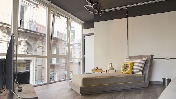 A modern bedroom with a large window, a bed, and a desk with a computer. - Toledo Loft (Naples)