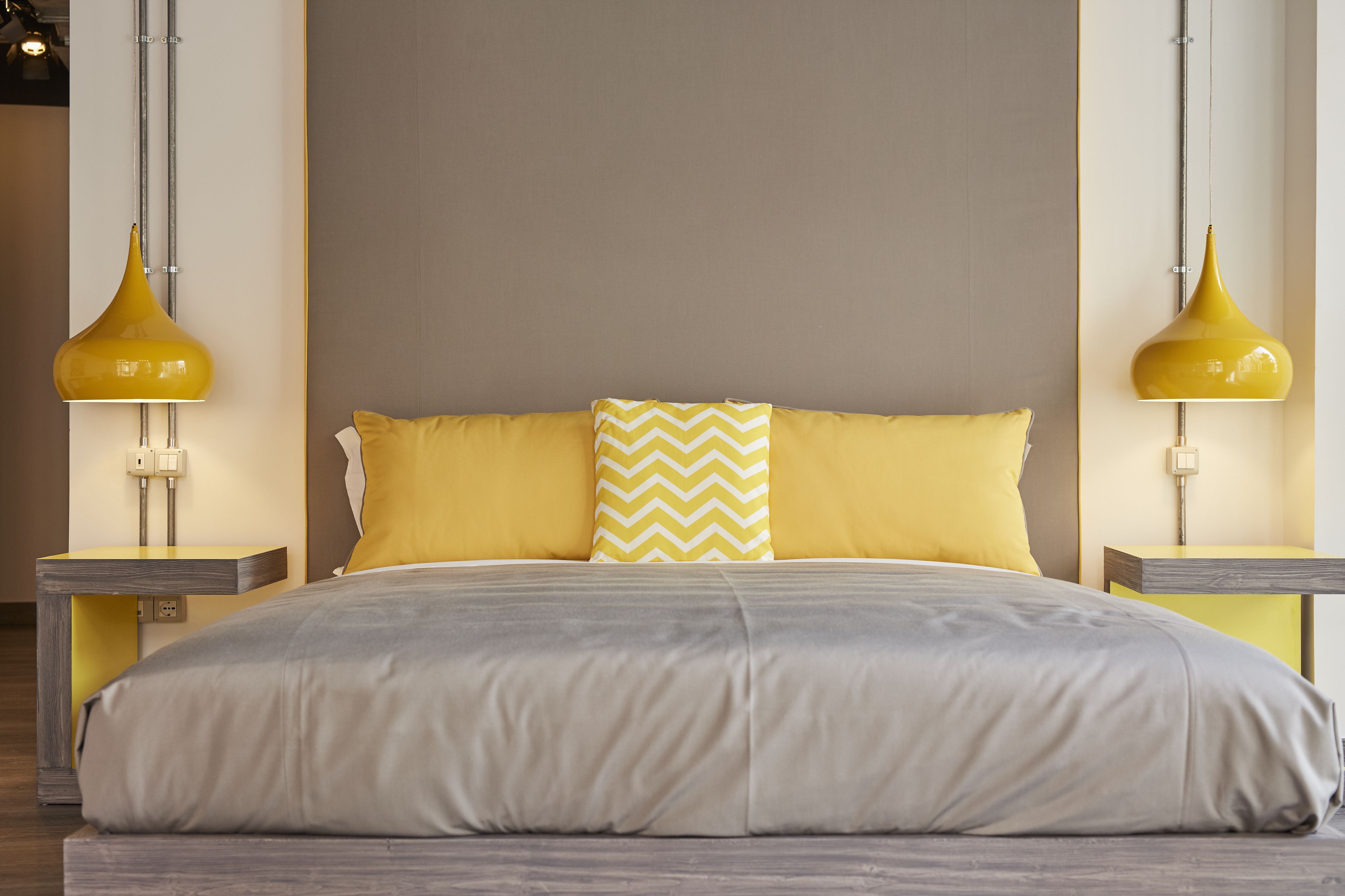 A modern bedroom with a large bed, two bedside lamps, and a neutral color scheme.