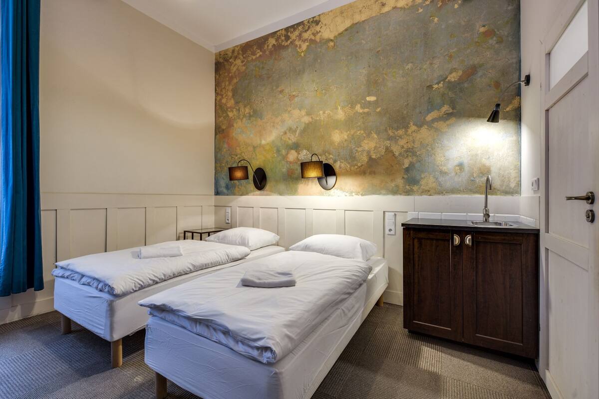 Habitación básica con 1 cama matrimonial o 2 individuales, vista a la ciudad | Escritorio, tabla de planchar con plancha, camas extra y wifi gratis