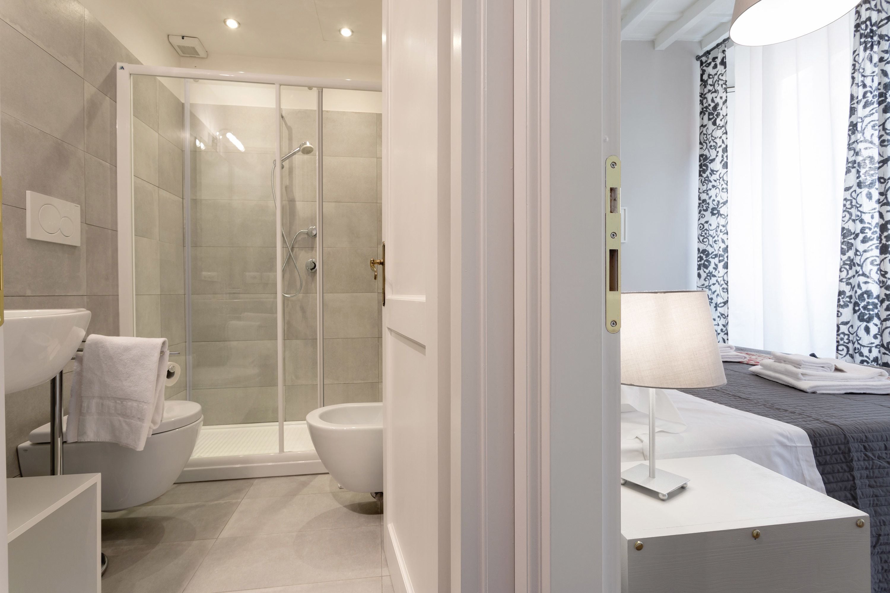 Une salle de bain moderne avec une douche à parois de verre, des toilettes et un lavabo.