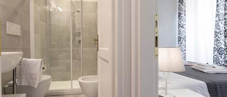 Une salle de bain moderne avec une douche à parois de verre, des toilettes et un lavabo.