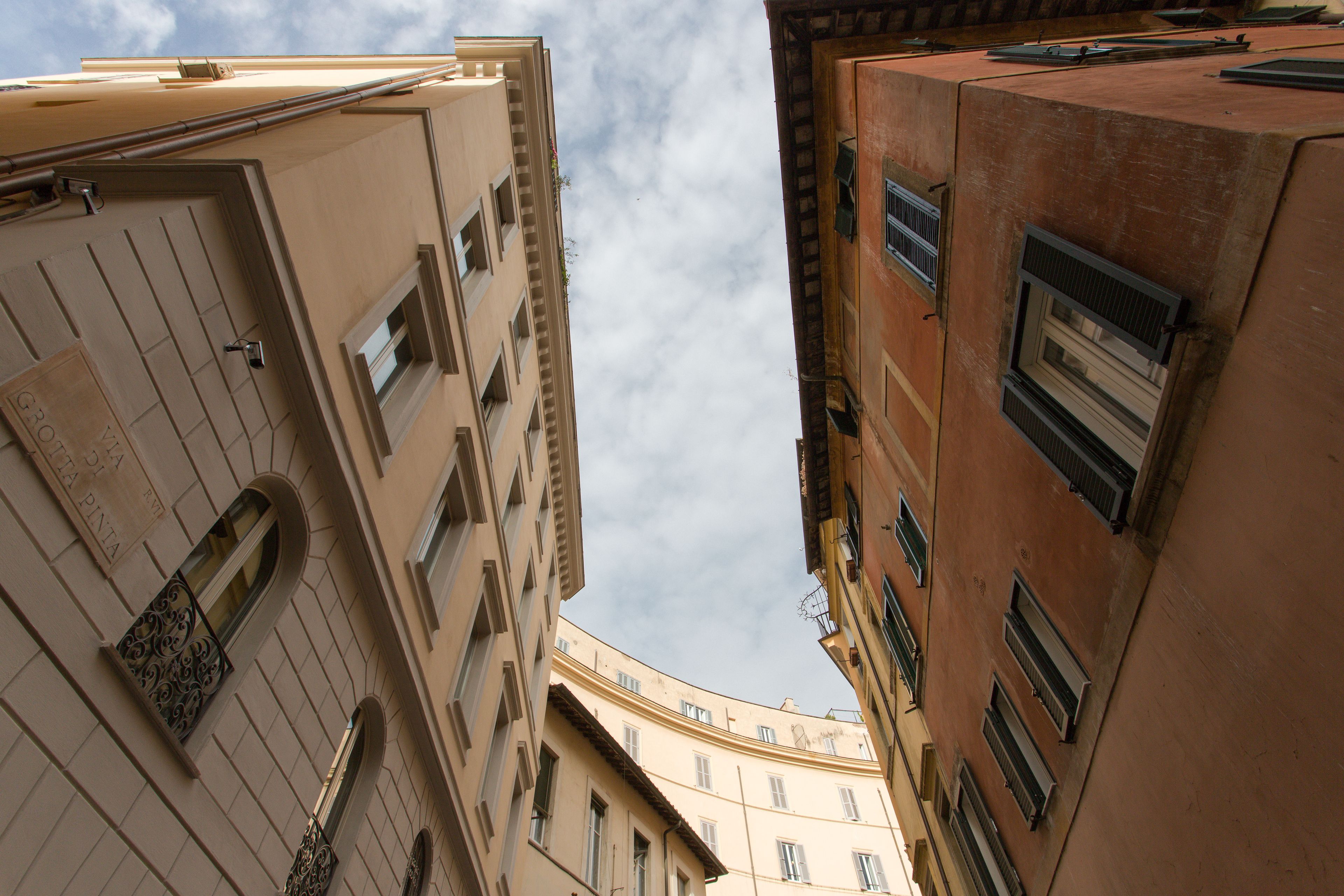 A view of a building's corner with multiple windows and balconies.