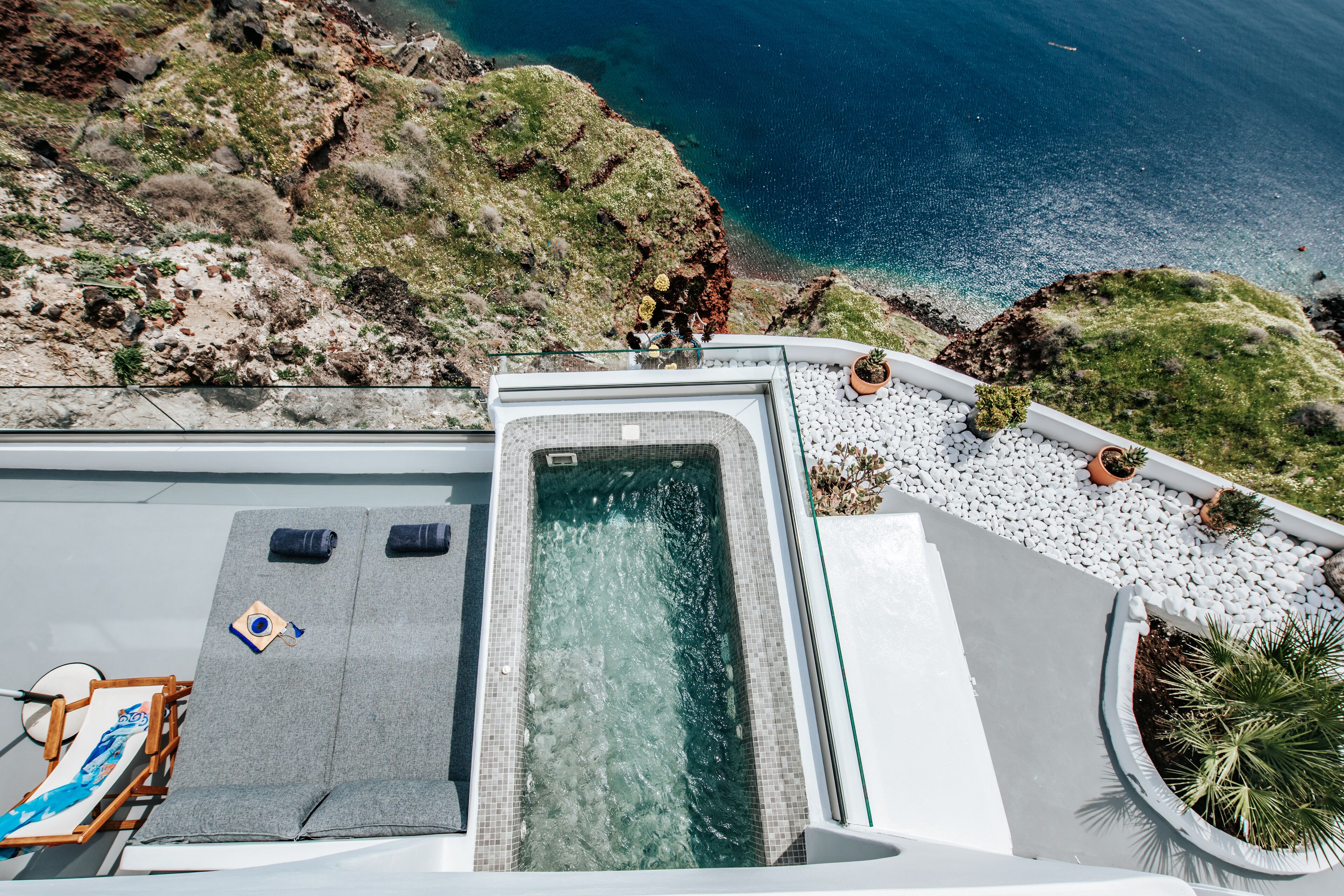 Una piscina en la azotea con vistas despejadas al océano y terreno rocoso.