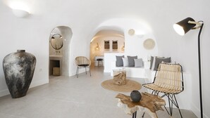 Una sala de estar moderna con un jarrón grande, una mesa de centro de madera y un sofá con cojines.