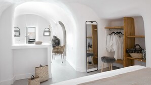 Un dormitorio moderno con un espejo grande, un armario y una zona de estar.
