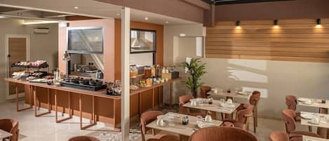Un comedor moderno con bufé, varias mesas y sillas.