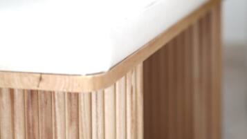 Un banc en bois avec un coussin blanc.