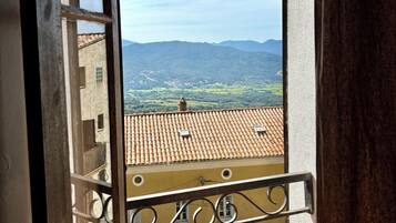 A balcony with a view of a mountainous landscape.