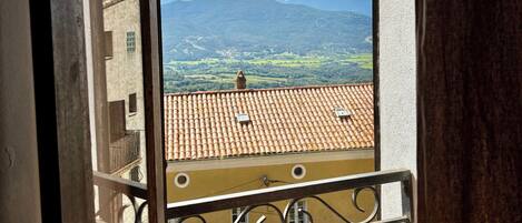 A balcony with a view of a mountainous landscape.