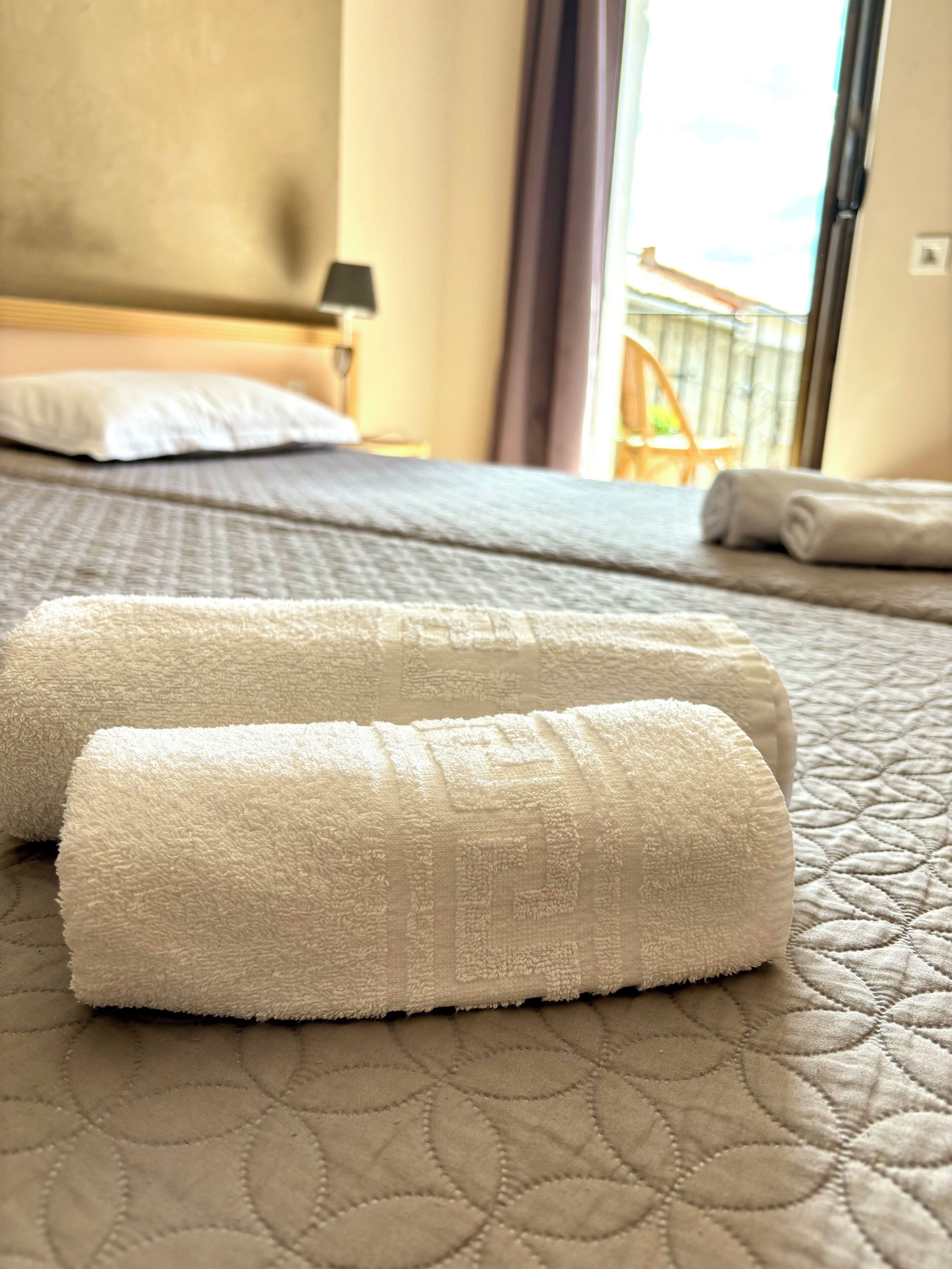 A hotel room with a bed, a window, and a view of the outside.