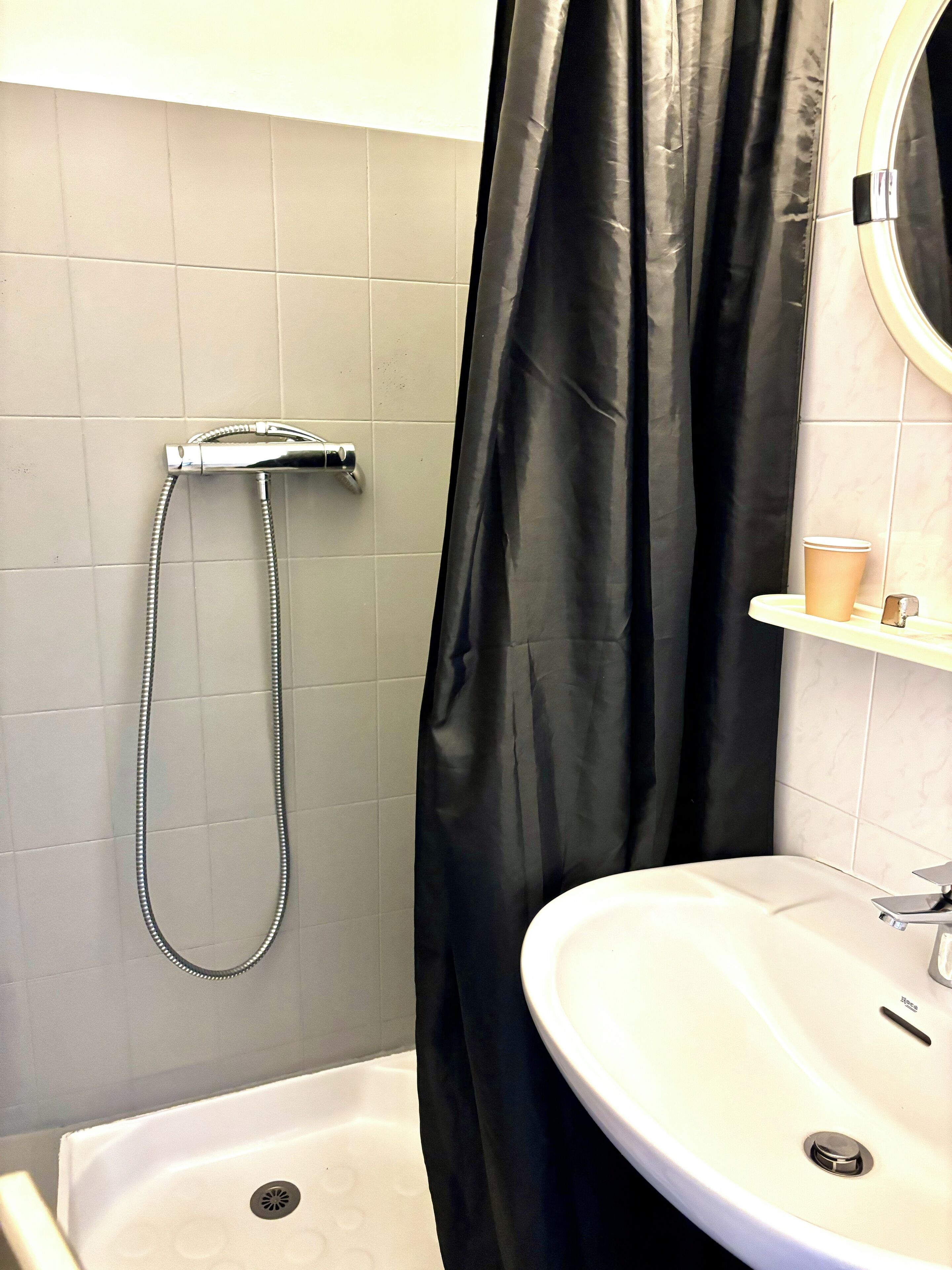 Une salle de bain avec une baignoire, une douche, un lavabo et un miroir.