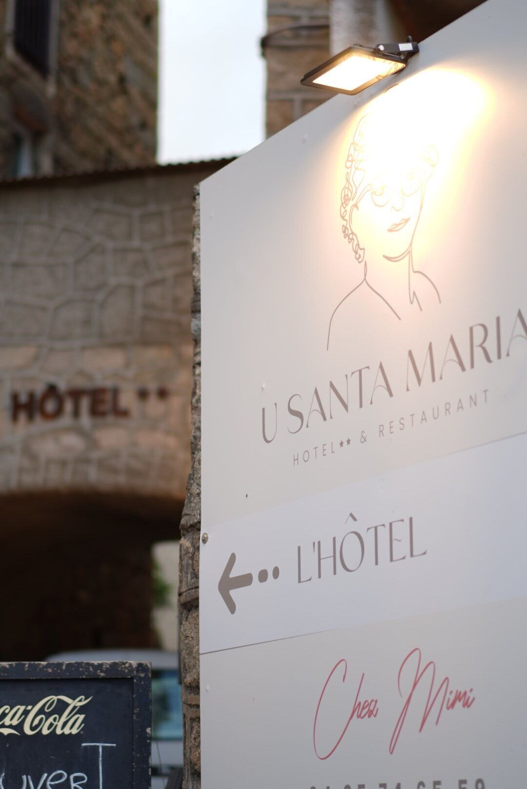 A sign for 'Usanta Maria Hotel & Restaurant' with a directional arrow pointing left.