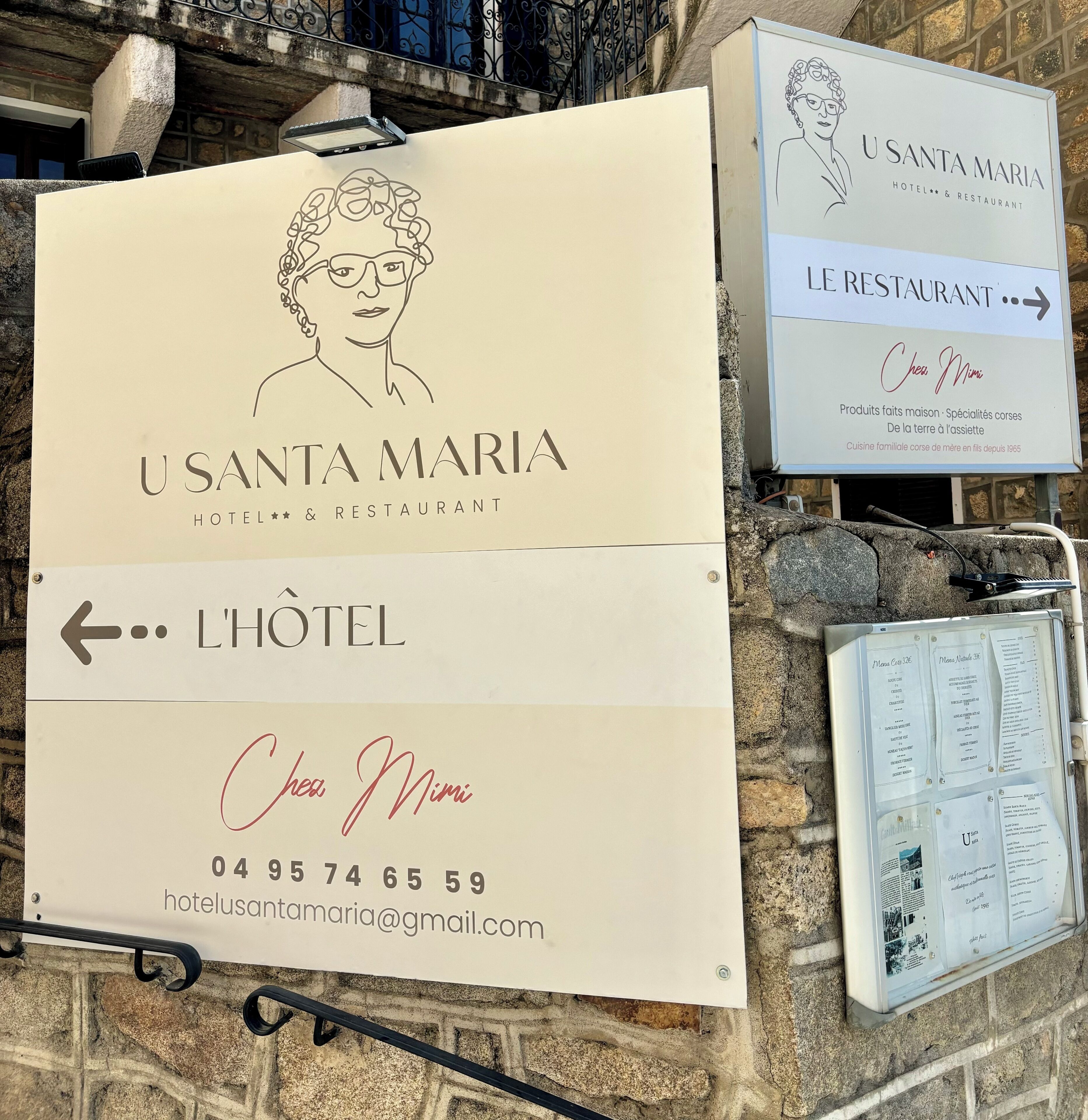 A hotel sign with the name 'USANTA MARIA HOTEL & RESTAURANT' and a direction to the hotel.