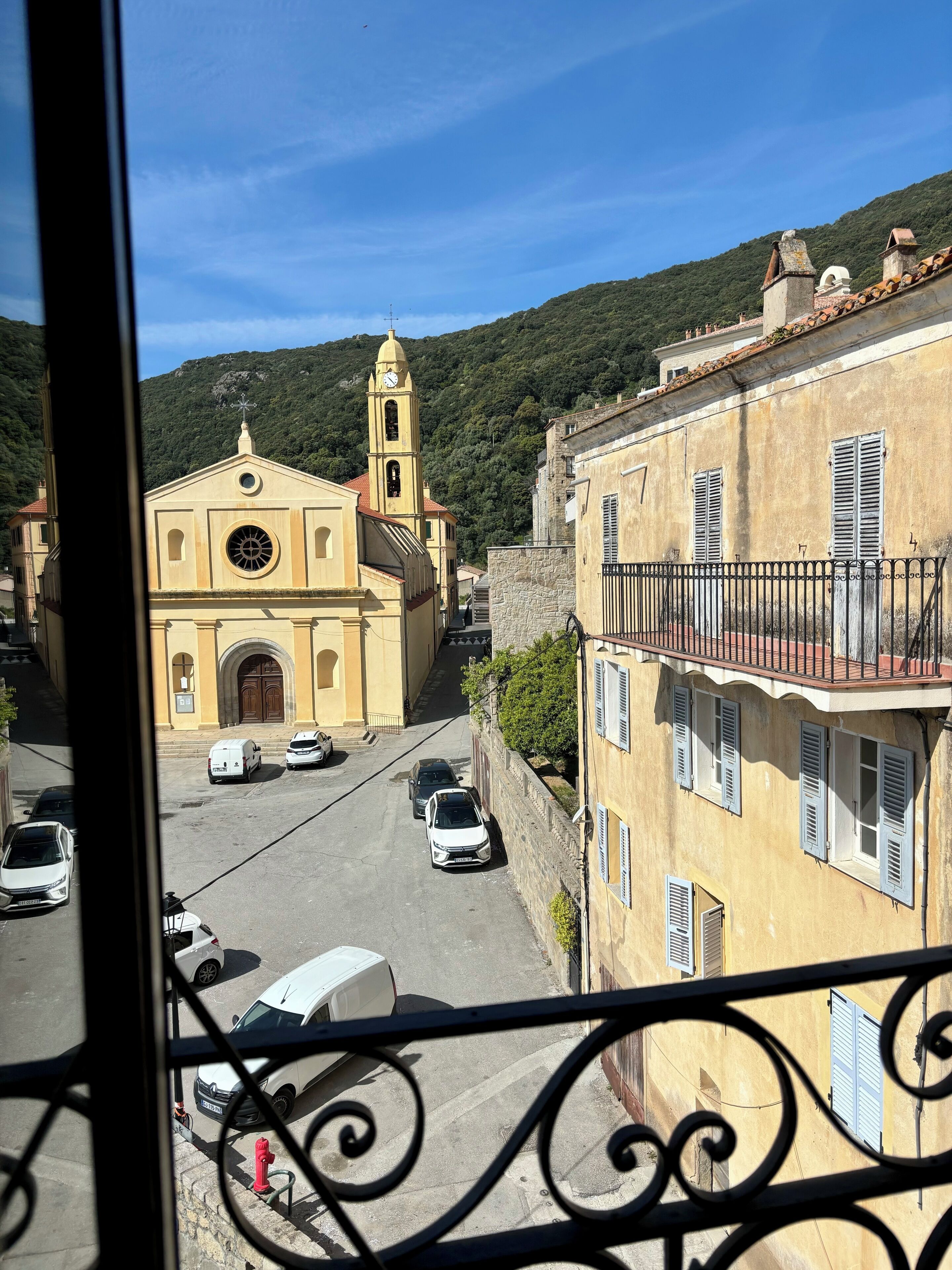A street view with a church, parked cars, and buildings.