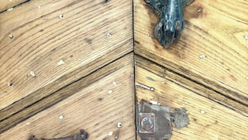 Sòl de fusta amb barana metàl·lica decorativa i una placa metàl·lica.