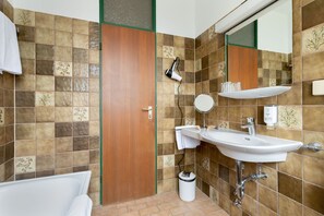 A bathroom with a sink, mirror, and towel rack. - Hotel Kolbergarten (Bad Toelz)