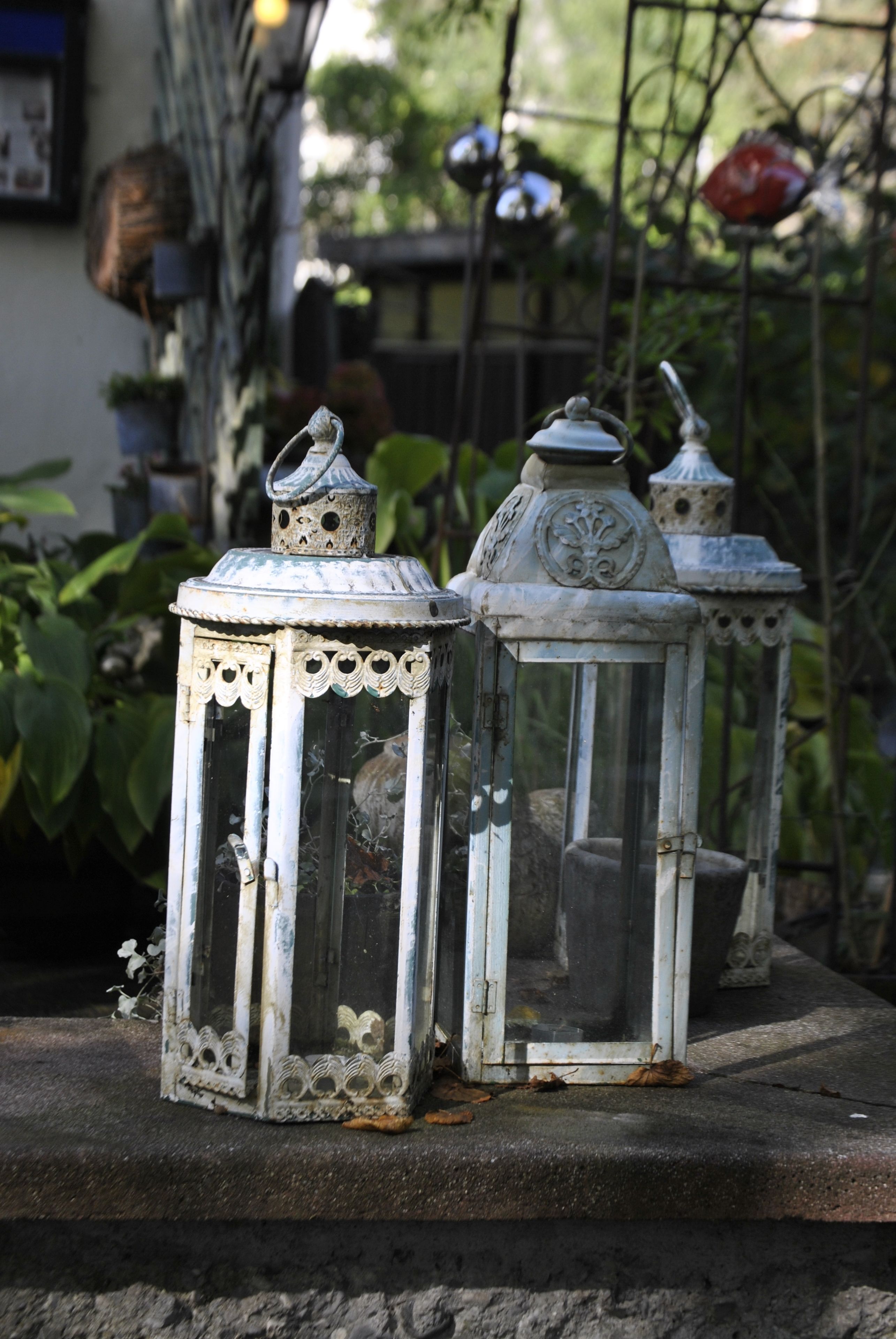 Two ornate, vintage-style lanterns placed on a stone ledge.