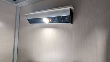 A ceiling-mounted air conditioning unit with a visible light indicator and a USB power supply port.